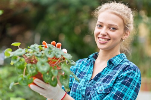 Gardener working in a small Chessington terrace garden with tools